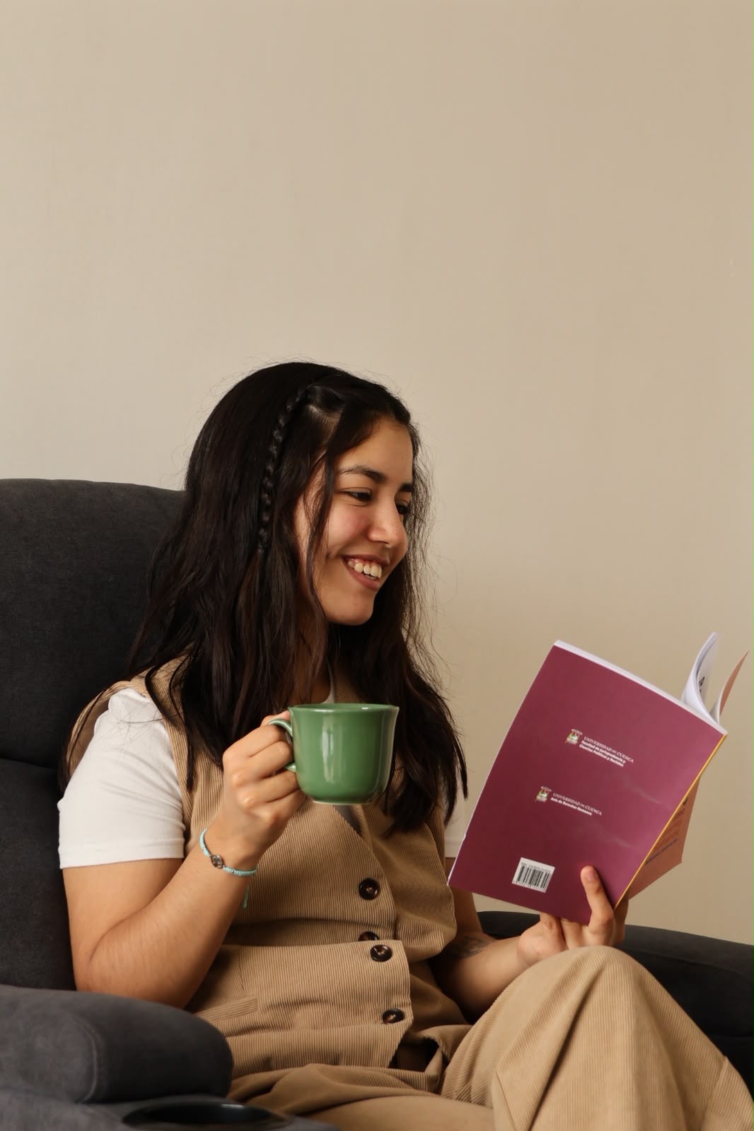 Ana María Reyes reading and holding a cup